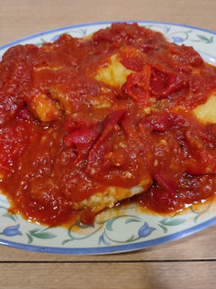 Una foto de Bacalao rebozado con tomate y pimientos asados