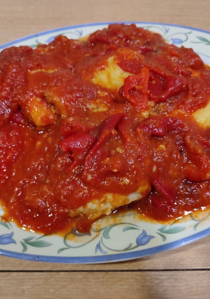 Una foto de Bacalao rebozado con tomate y pimientos asados