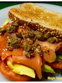 Una foto de Sándwich de trucha ahumada con tomate, aguacate y alcaparras