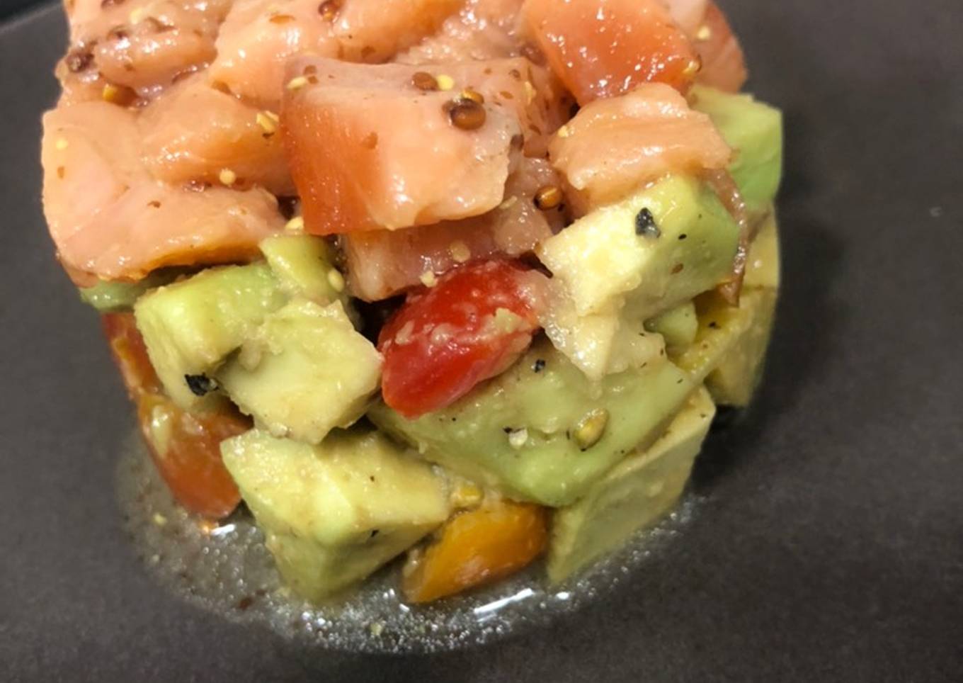 Tartar de salmón sobre aguacate y tomates cherry