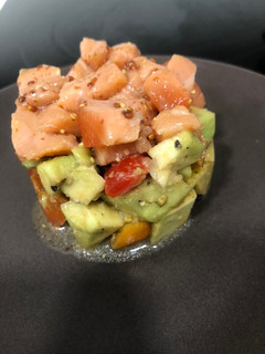 Una foto de Tartar de salmón sobre aguacate y tomates cherry