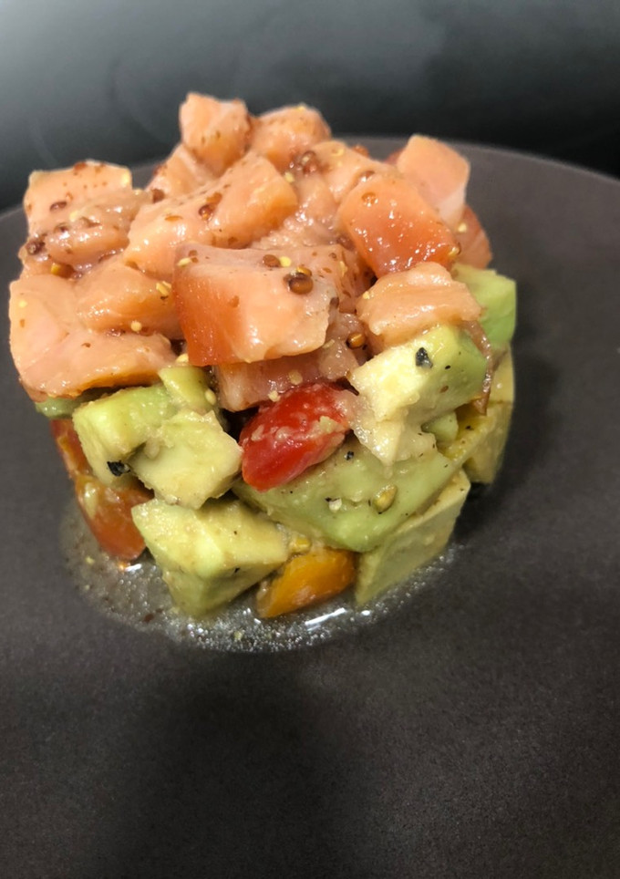 Una foto de Tartar de salmón sobre aguacate y tomates cherry