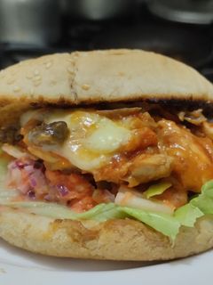 Una foto de Sándwich de pollo🍗en salsa de tomate🍅casera con queso🧀y ensalada cremosa🥙🥯🍔