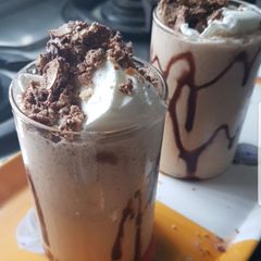 A picture of Cold coffee with crumbled Ferrero Rocher.