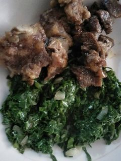 A picture of Fried beef with greens.