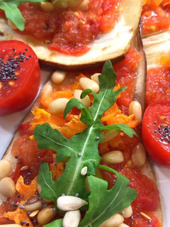 Una foto de Berenjenas horneadas con tomate semillas y diente de león