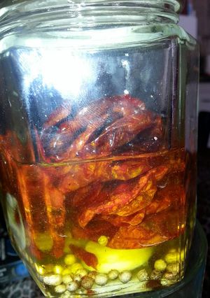 Una foto de Tomates deshidratados en aceite de oliva con pimienta en granos y ajo