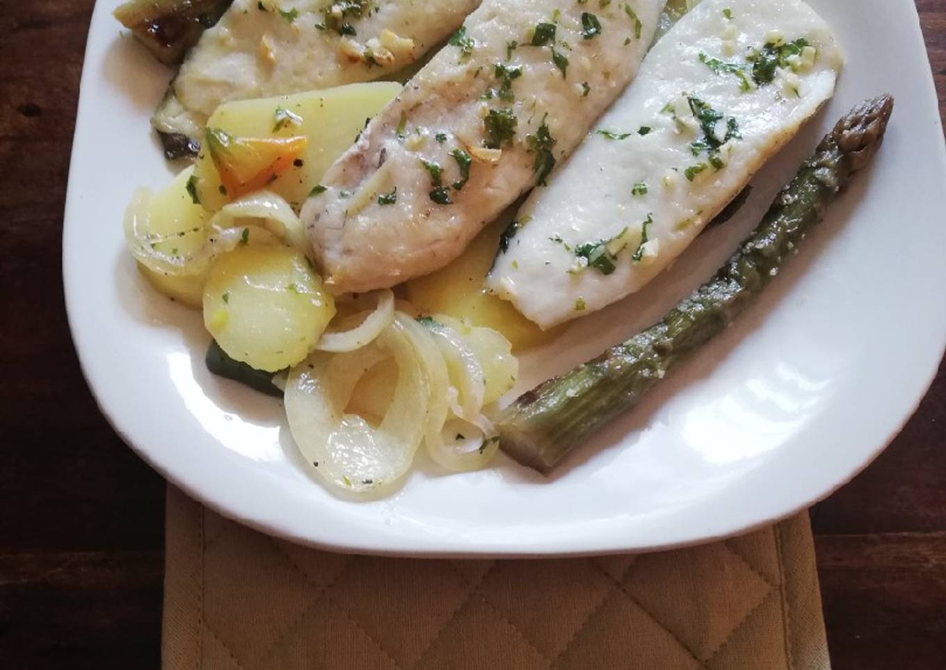 Lomitos de Merluza al horno sobre lecho de patatas y hortalizas