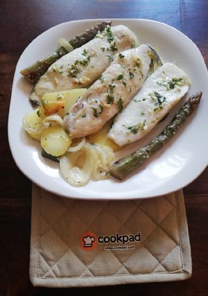 Una foto de Lomitos de Merluza al horno sobre lecho de patatas y hortalizas