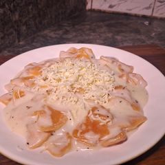 A picture of Farfalle cheezy pasta with white sauce.