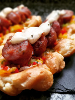Una foto de Choripan con salsa criolla en base de masa choux