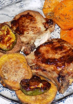 Una foto de Costillitas de cerdo con batatas azucaradas y zapallo al romero