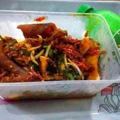 A picture of Roasted yam garnished with vegetable and ponmo sauce.