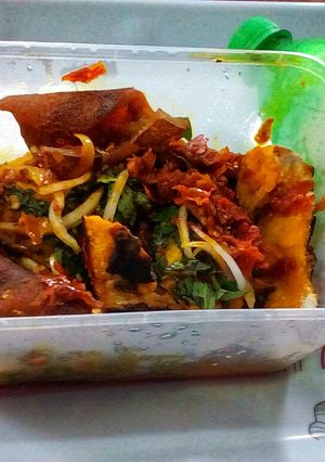 A picture of Roasted yam garnished with vegetable and ponmo sauce.
