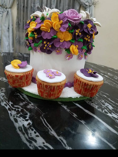 A picture of Butter Cake Covered in fondant With Royal icing flowers.