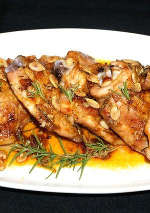 A picture of Roasted chicken thighs with fresh rosemary.