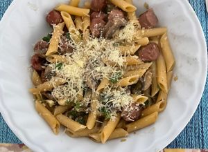 Una foto de Penne rigatti con hongos portobello, salchicha parrillera y cebolla de verdeo