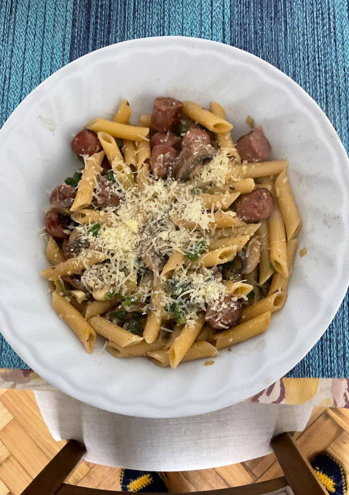 Una foto de Penne rigatti con hongos portobello, salchicha parrillera y cebolla de verdeo