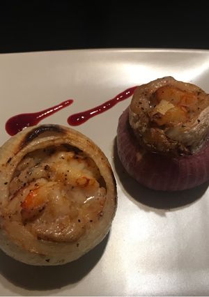 Una foto de Pescado y langostinos en cebolla