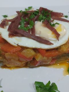 Una foto de Tarta de pisto, base de patatas, con huevos y tiritas de jamón