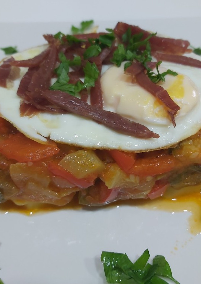 Una foto de Tarta de pisto, base de patatas, con huevos y tiritas de jamón