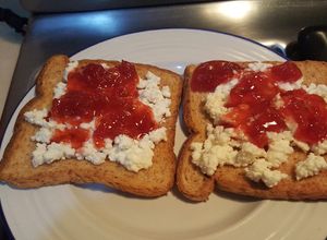 Una foto de Tostada integral con queso ricota y mermelada de tómates