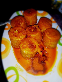 A picture of Moi Moi coated with palm oil nd ground pepper (yaji).