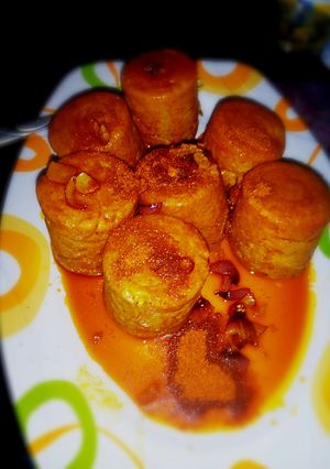 A picture of Moi Moi coated with palm oil nd ground pepper (yaji).
