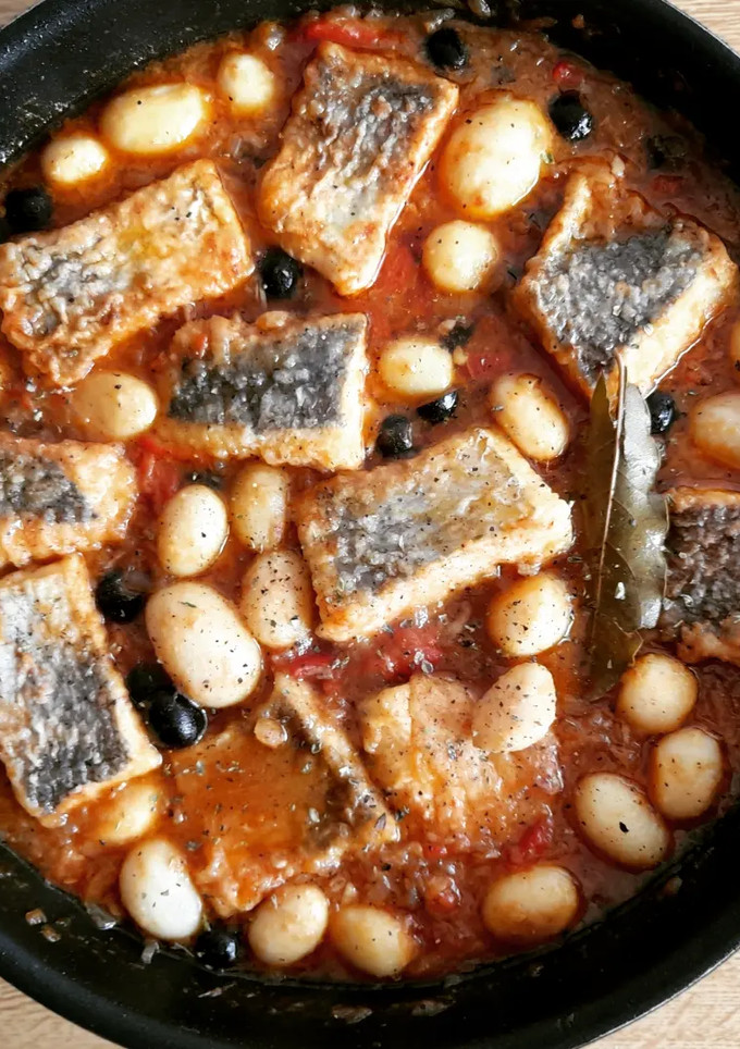 Una foto de Merluza en salsa con pimientos y ajos escalivados