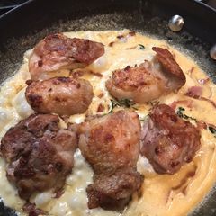 A picture of Chicken thighs with cream, thyme and bacon.