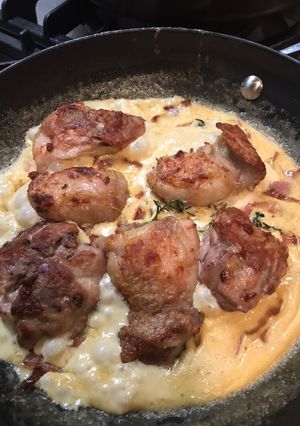 A picture of Chicken thighs with cream, thyme and bacon.