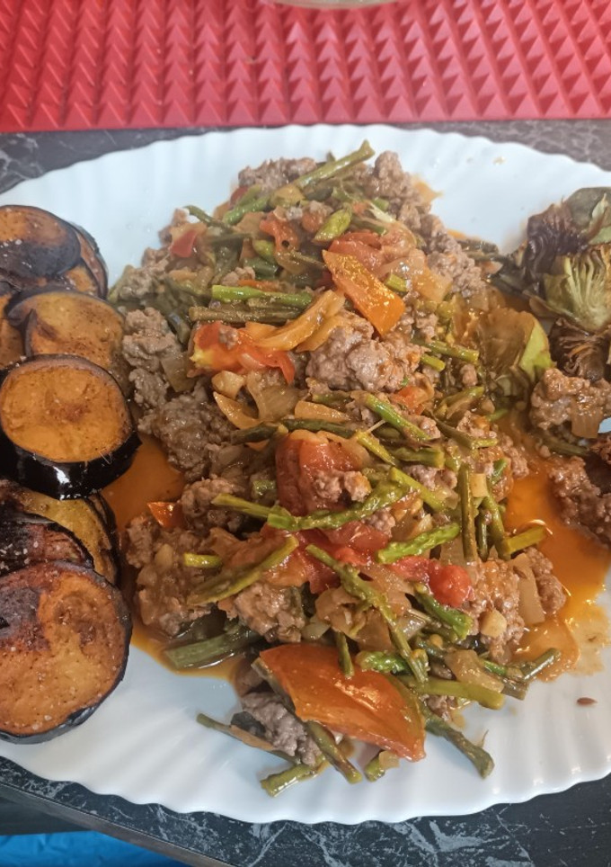 Una foto de Carne picada con espárragos trigueros, tomate y cebolla