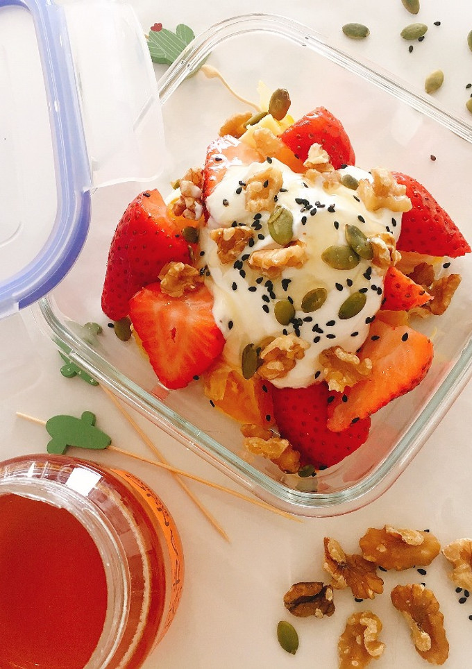 Una foto de Almuerzo en tupper: fresas, naranja y yogur griego con nueces y semillas🍓