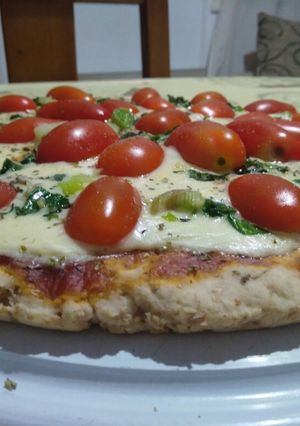 Una foto de Pizza integral de tomate y verdeo