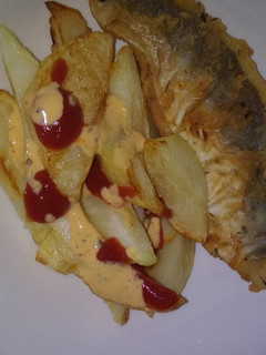 A picture of Fried Chips with tomato sauce and chilli sauce.