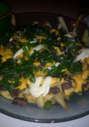 Una foto de Papas con cheddar y algo más