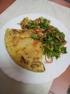 Una foto de Tortilla de papas, zanahoria y calabacín con ensalada
