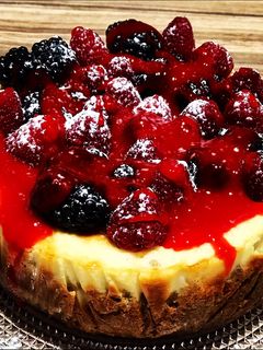 Una foto de Cheesecake de vainilla, frambuesas y moras con salsa de frutos rojos