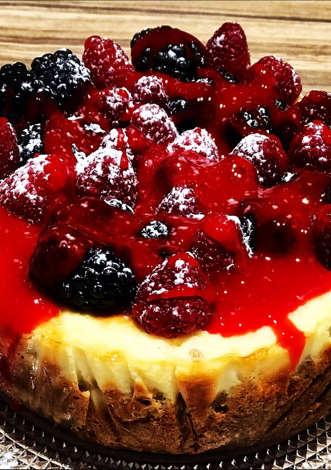 Una foto de Cheesecake de vainilla, frambuesas y moras con salsa de frutos rojos