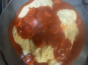 Una foto de polenta con salsa de salchicha