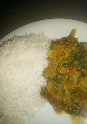 A picture of White rice with spinach and egg sauce.