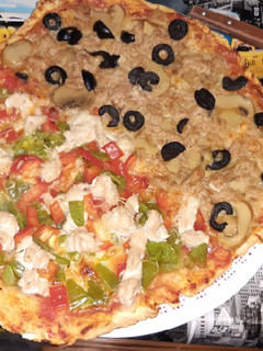 Una foto de Pizza mitad pollo mitad atún