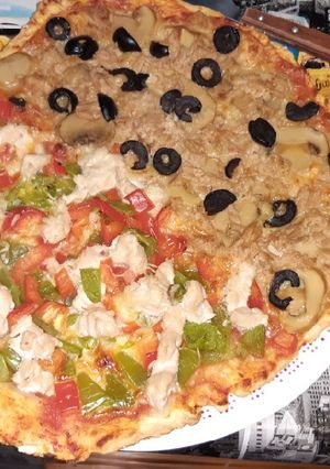 Una foto de Pizza mitad pollo mitad atún