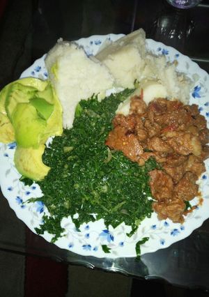 A picture of Ugali sukuma served with mutton and guacamole.