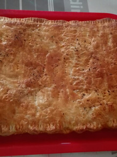 Una foto de Empanada de hojaldre rellena de atún y tomate