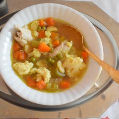 A picture of Chicken and vegetable soup with semolina dumplings.