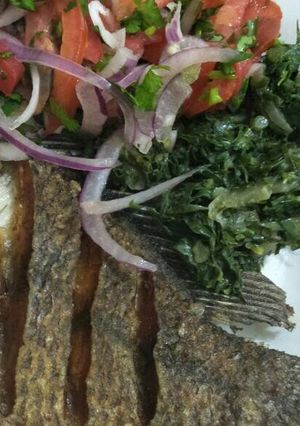 A picture of Fried fish with greens and kachumbari.