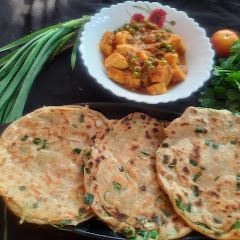 A picture of Green garlic laccha paratha with matar paneer.