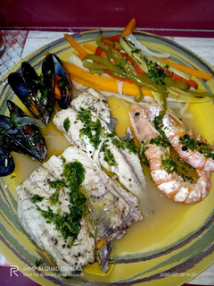 Una foto de Corvina en su jugo, con verduras