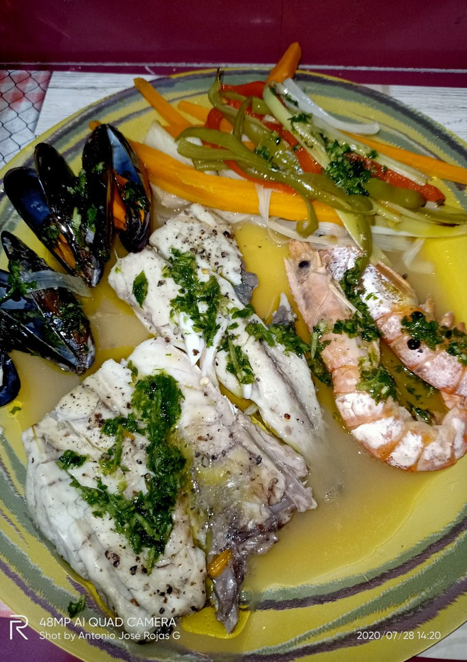 Una foto de Corvina en su jugo, con verduras
